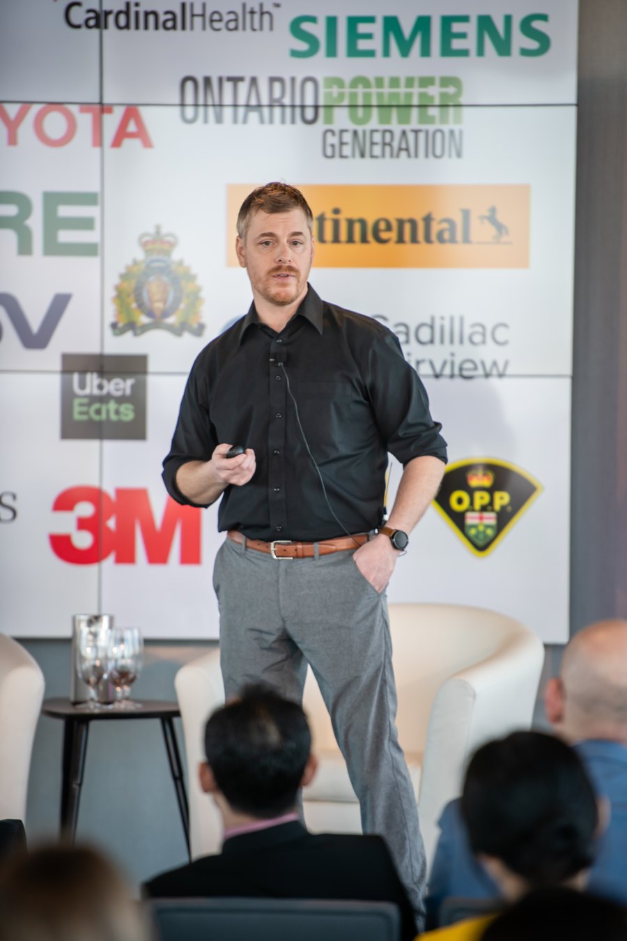 Cameron Waite speaking at a conference, in front of a slide showing a delivery route map